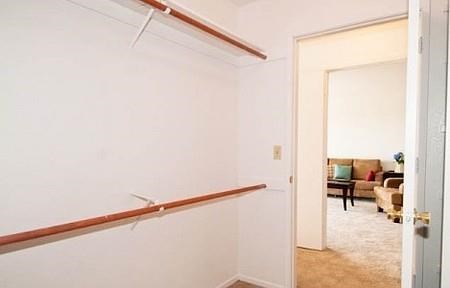 a white hallway with a railing and a living room