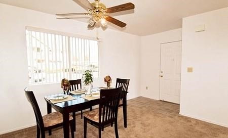 a dining room with a table and a ceiling fan