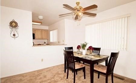 a dining room with a table and chairs and a ceiling fan