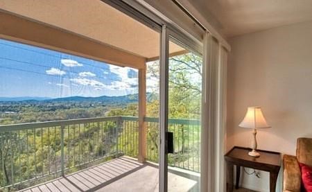 a living room with a large window and a balcony
