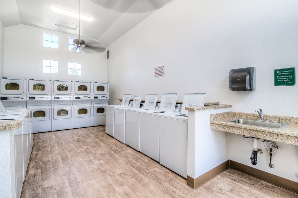 a laundry room with washers and dryers and sinks and washing machines