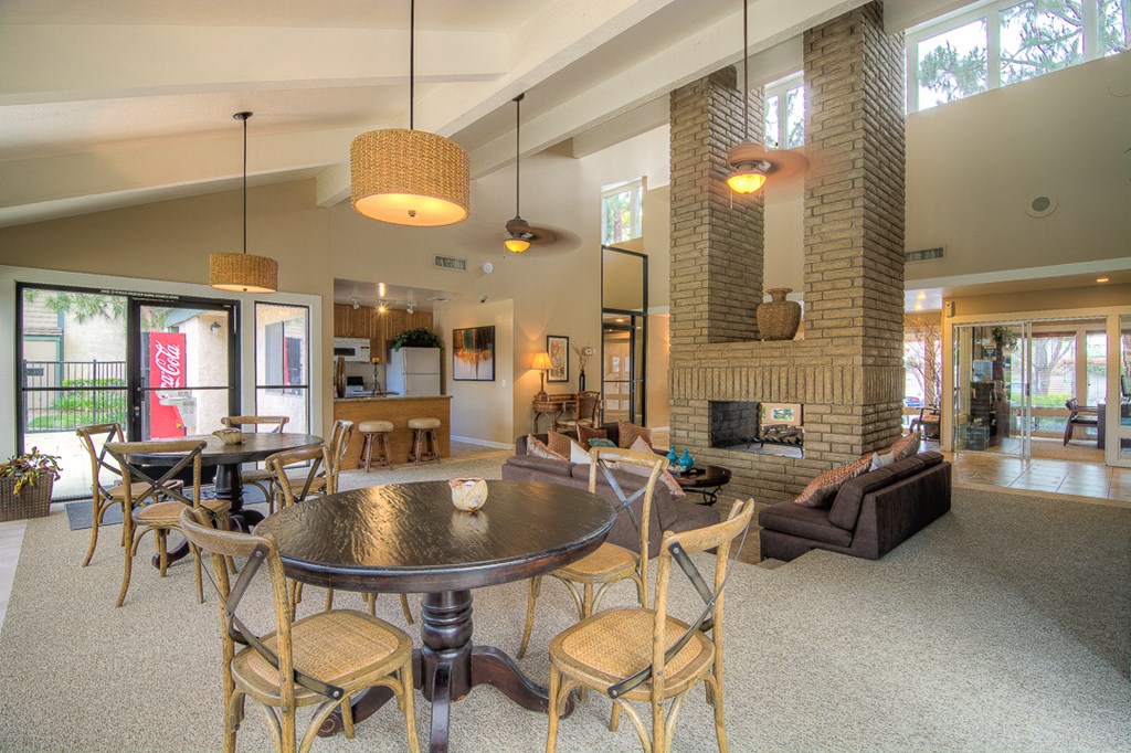 a living room with a table and chairs and a fireplace