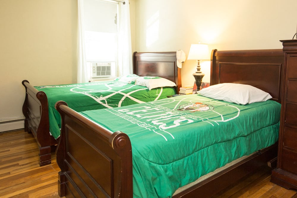 a bedroom with a bed with a green comforter on it