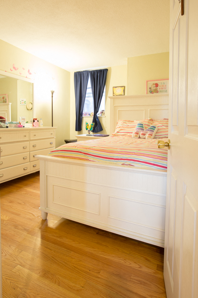 a bedroom with a bed and a dresser and a window