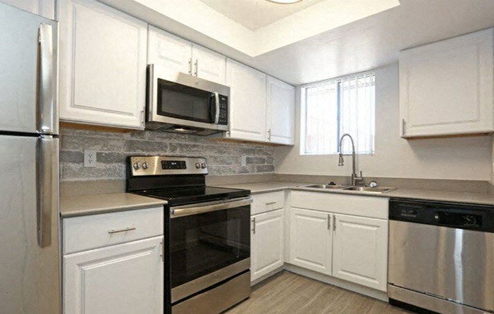 a kitchen with stainless steel appliances and white cabinets