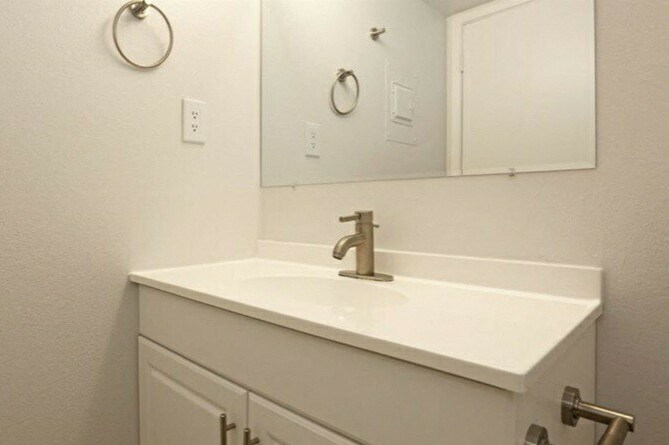a white bathroom with a sink and a mirror