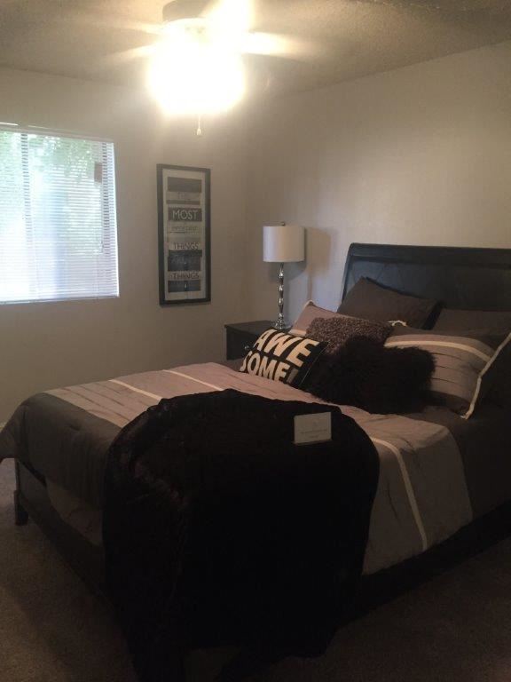 a bedroom with a bed and a lamp and a window