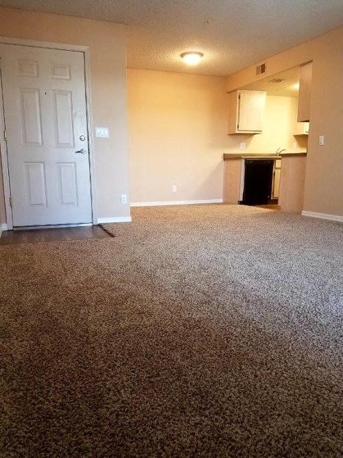 an empty living room with a white door