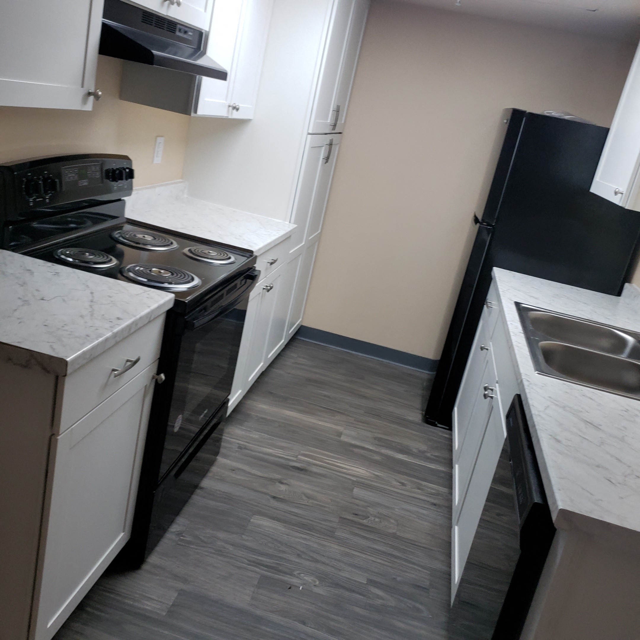 a kitchen with a stove and a refrigerator and a sink