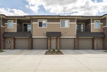 A row of townhouses with garages in front.