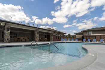 A swimming pool with a slide and a building in the background.