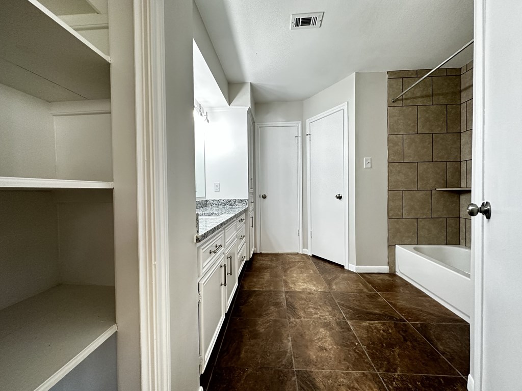 a view of a kitchen with white cabinets and tiled floors