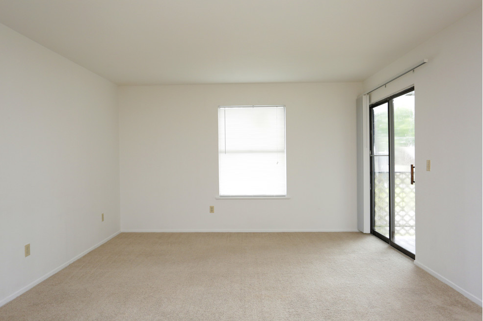 an empty room with a window and a door