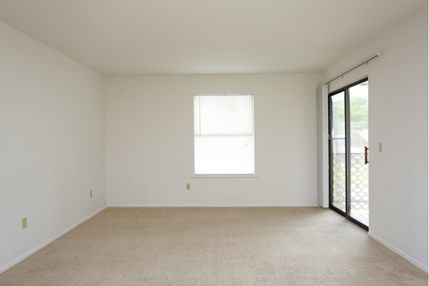 an empty room with a window and a door