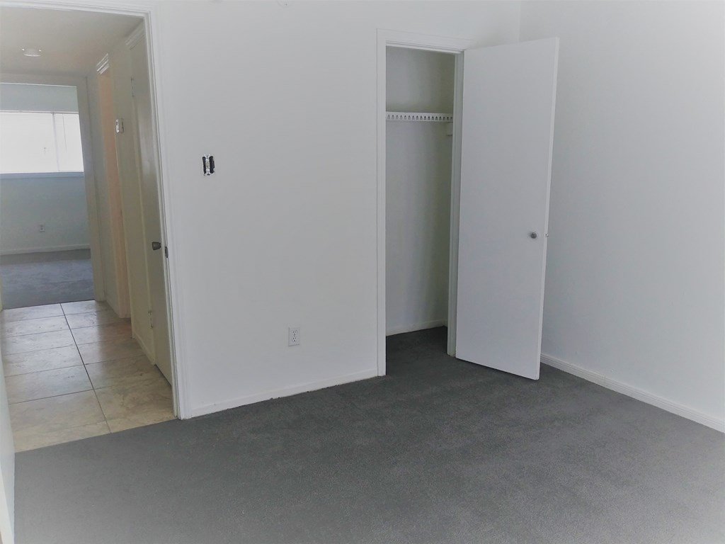 an empty living room with white walls and doors