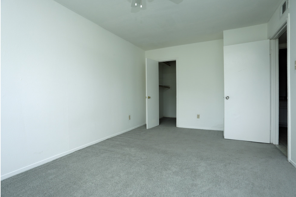 an empty living room with white walls and a carpet