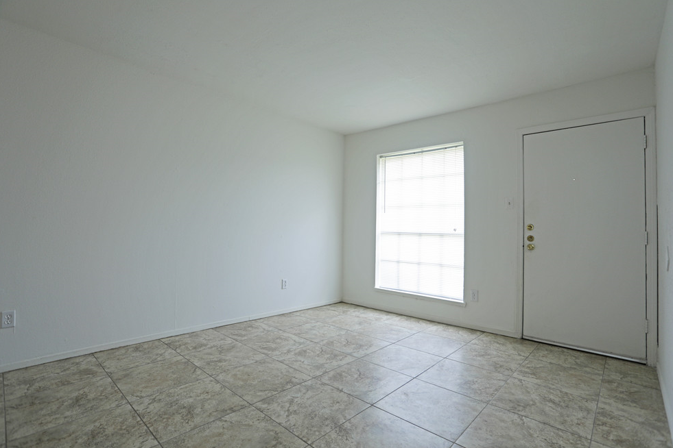 an empty room with white walls and a window and a door