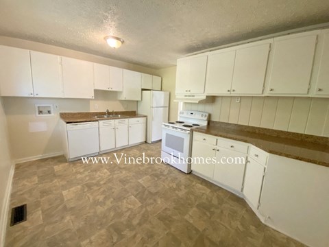 A kitchen with white cabinets and a microwave.