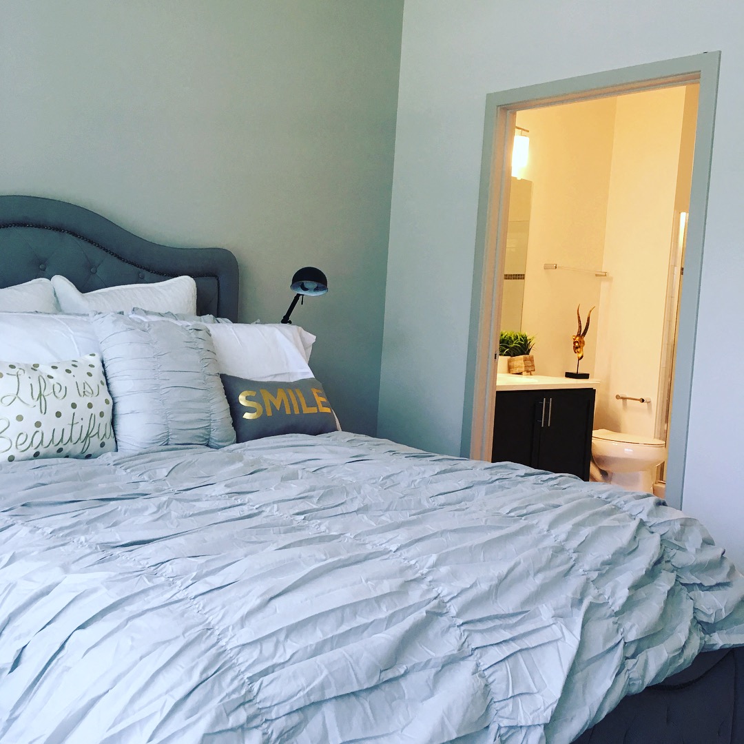 a blue and white bed in a small room with a bathroom