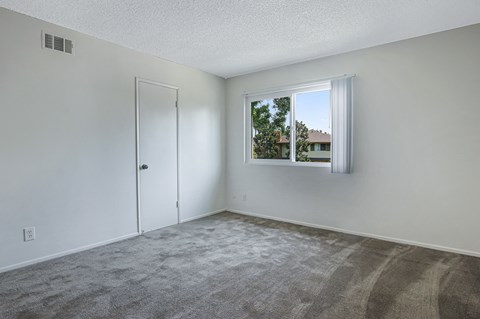 an empty living room with a window and a door