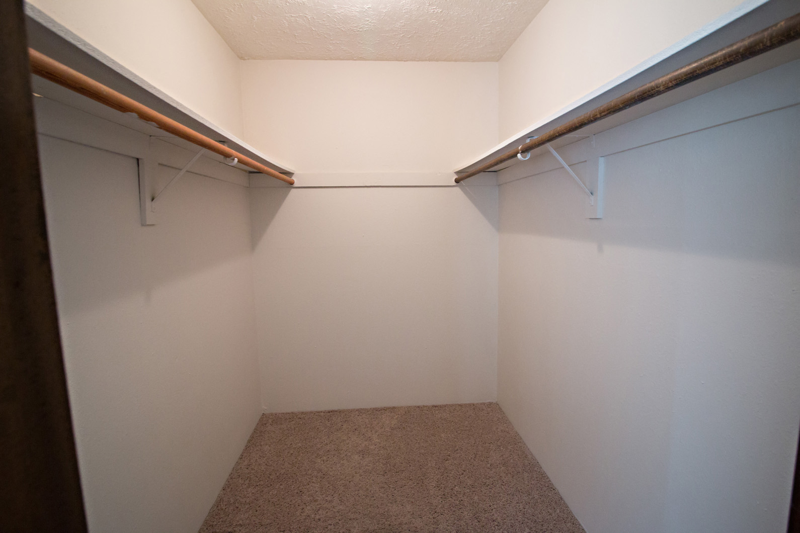 a walk in closet with two closets and a carpet