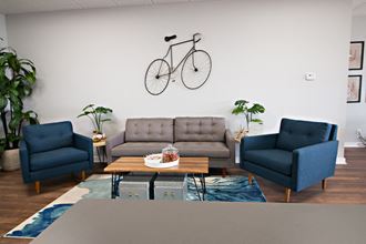 a living room with couches and chairs and a bike on the wall