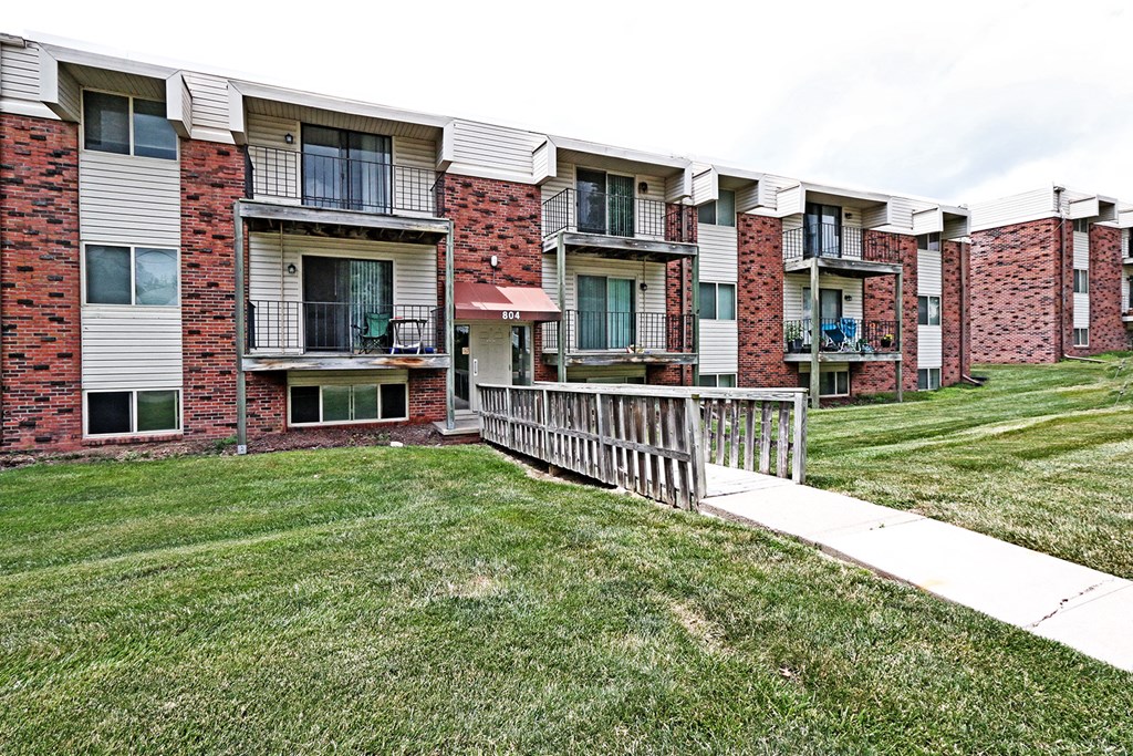 the outlook of an apartment building with a wooden fence