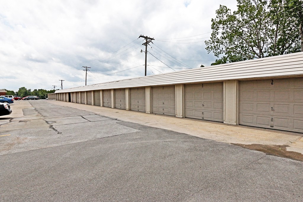 an empty parking lot with a row of garages