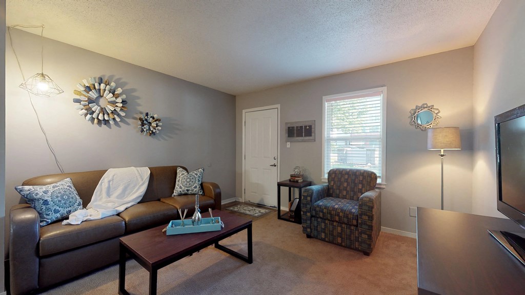 a living room with a couch and a chair and a tv