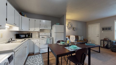 an open kitchen and living room with a dining room table