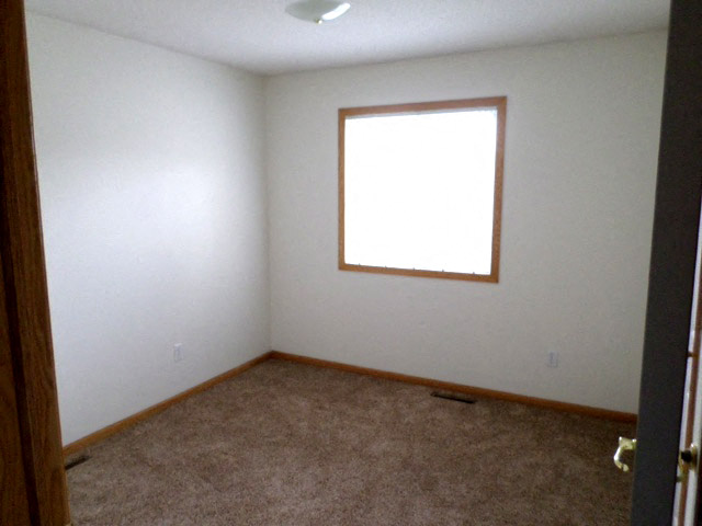 an empty room with a window and a carpet