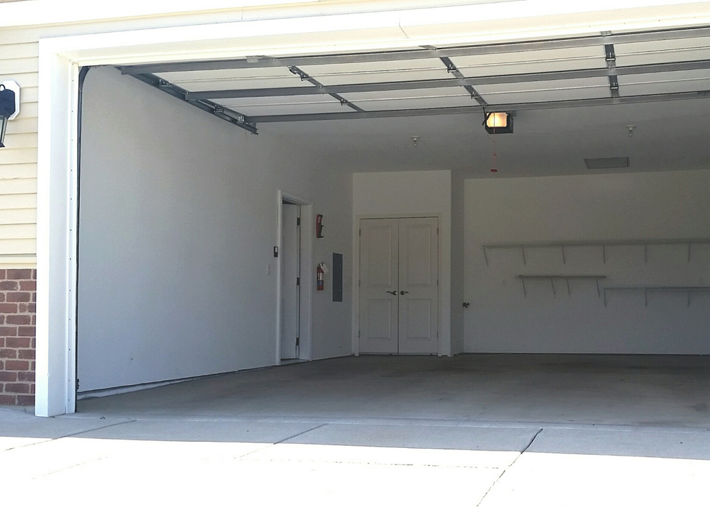 the inside of a garage with a door open
