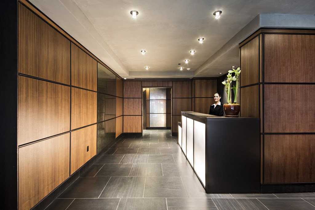 a lobby with wooden cabinets and a black reception desk