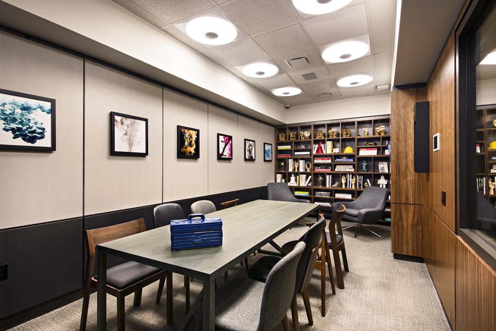 a large room with tables and chairs and a bookshelf