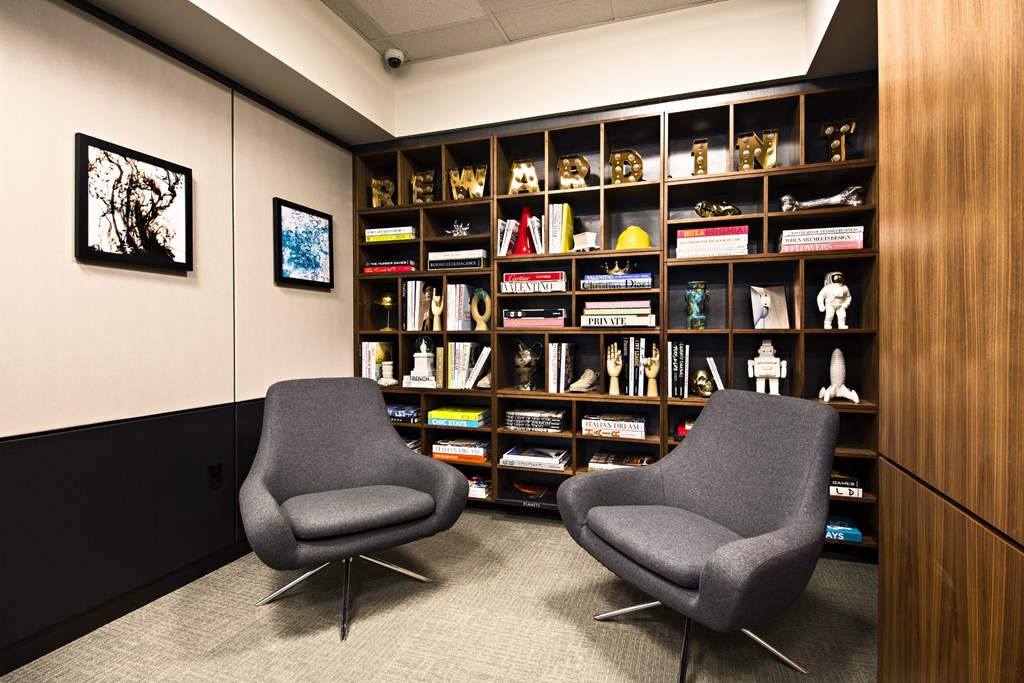 two chairs in front of a wall of bookshelves in a room