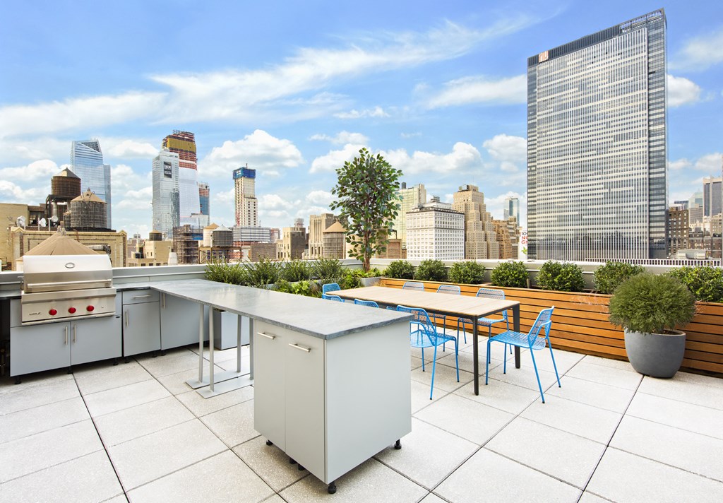 a roof terrace with a table and chairs and a view of the city
