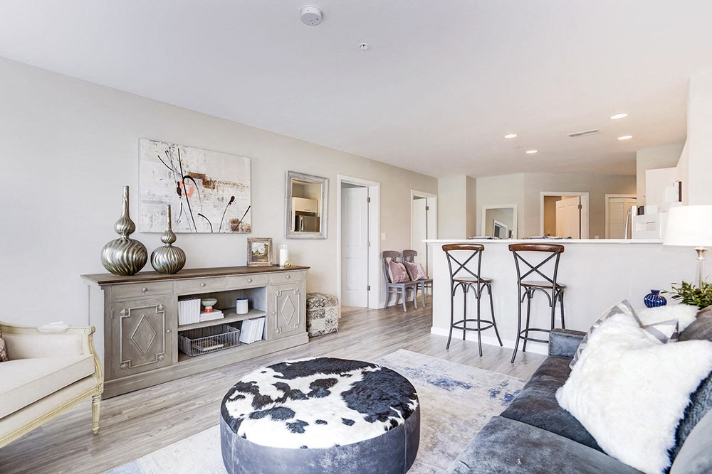 a living room with a couch and a table in front of a kitchen