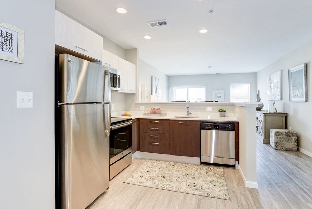 a renovated kitchen with stainless steel appliances and wooden floors