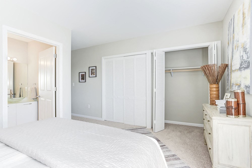 a bedroom with a bed and a closet and a bathroom