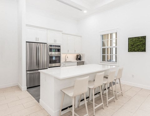 the kitchen has a large island and stainless steel appliances