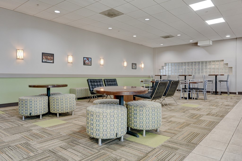 a seating area with tables and chairs in a lobby