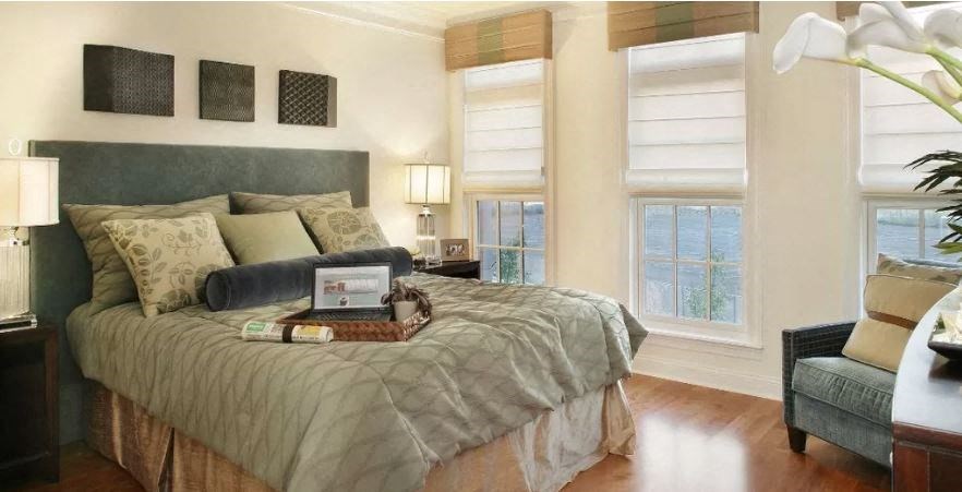 a bedroom with a bed and a laptop on it