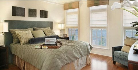 a bedroom with a bed and a laptop on it