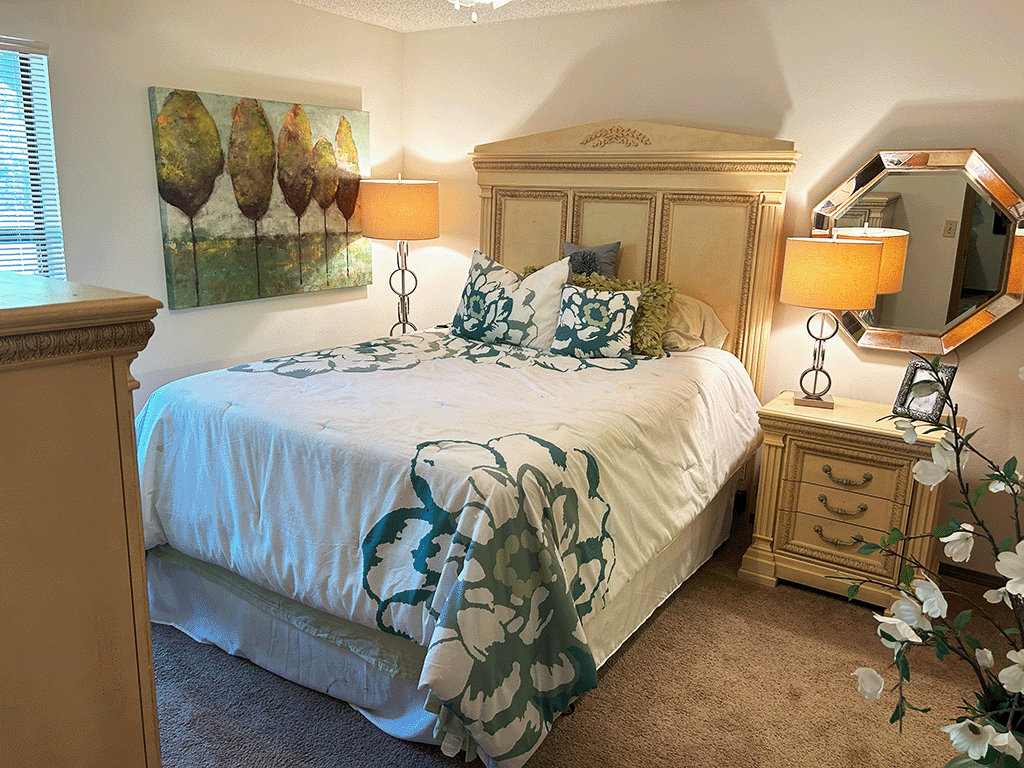 a bedroom with a bed and two lamps and a dresser