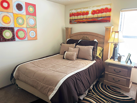 a bedroom with a bed and paintings on the wall