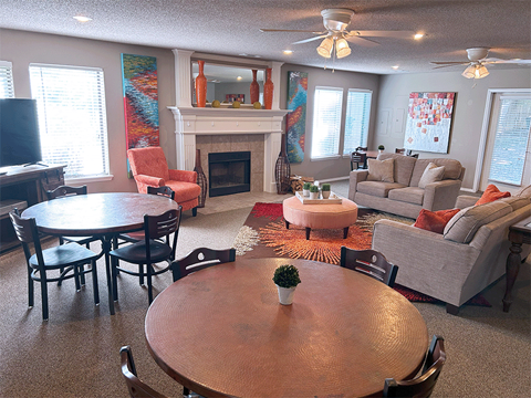 a living room with a table and chairs and a fireplace