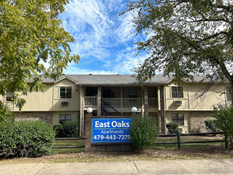 an apartment building with a sign for east oaks apartments