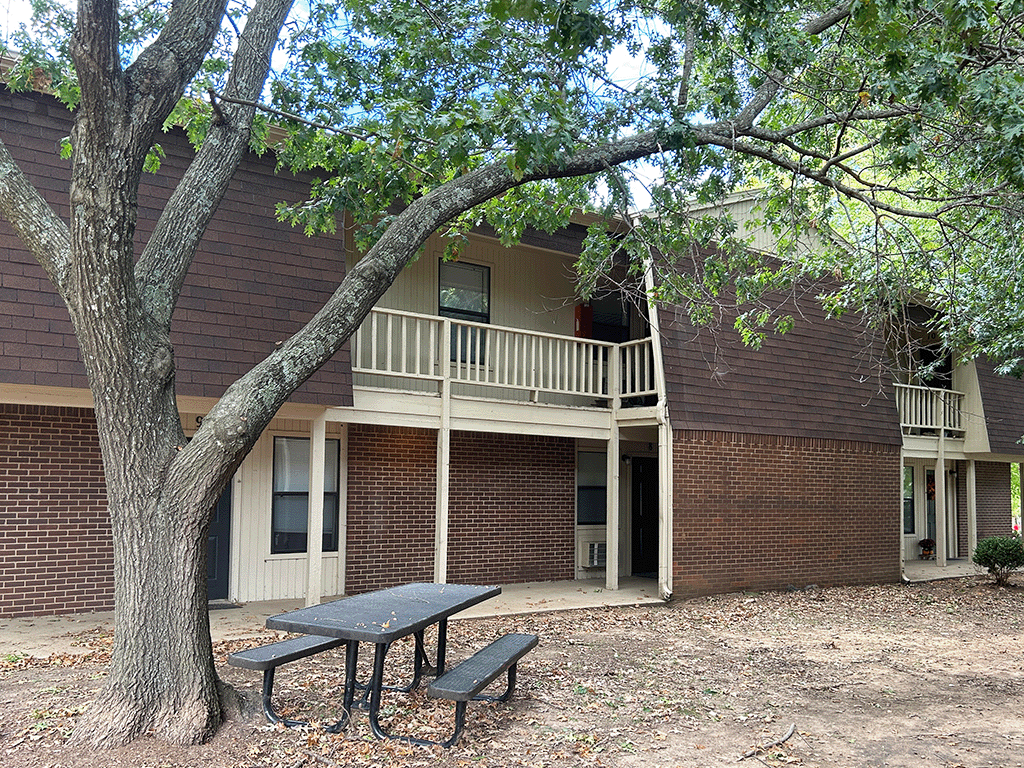 a building with a table and a tree in front of it