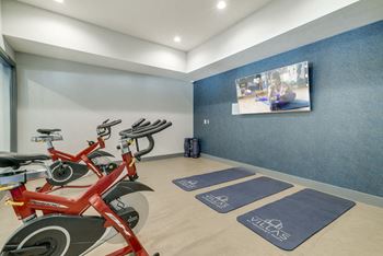 Yoga studio with bikes and television at The Villas at Mahoney Park in North Lincoln, Nebraska