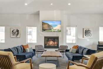 Sofas and chairs around a fire place and mounted TV